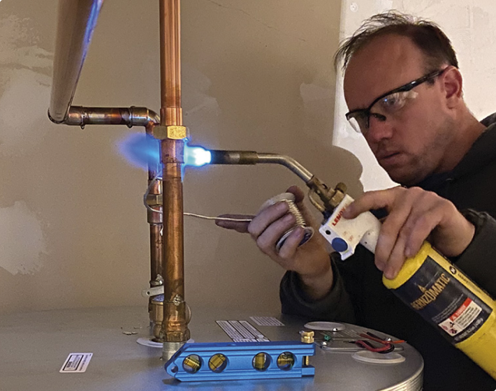 One of our skilled technicians soldering pipe during an HVAC Maintenance visit